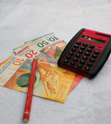 Schweizer Franken Banknoten und ein Rechner, die die finanzielle Thematik der Pressemitteilung über die Lohnoptimierung des Bundes illustrieren.